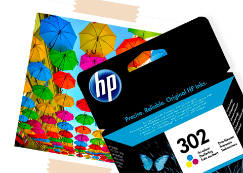 A HP 302 Ink Cartridge, next to a printed photo of multicolour umbrellas