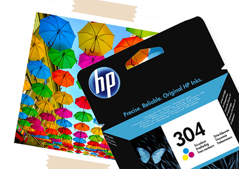 A HP 304 Ink Cartridge, next to a printed photo of multicolour umbrellas